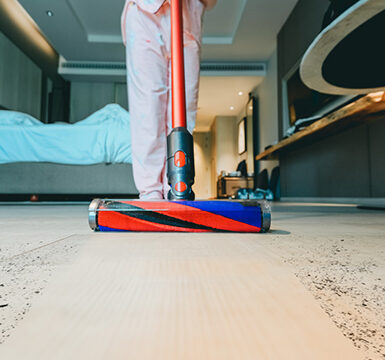 A person using a vacuum on the floor