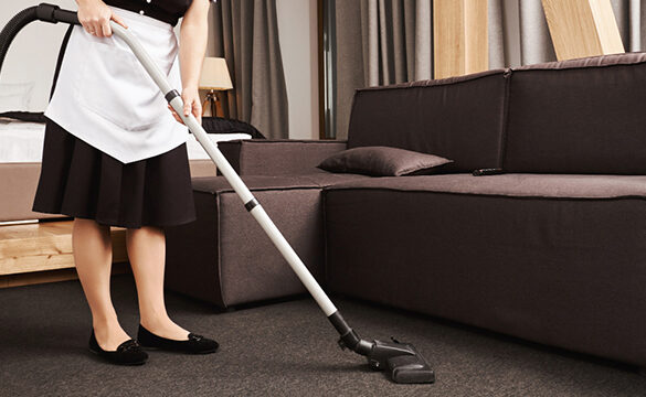 A woman is vacuuming the floor in her living room.