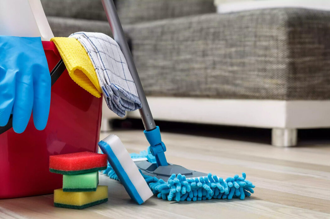 A mop, bucket and cleaning supplies on the floor.